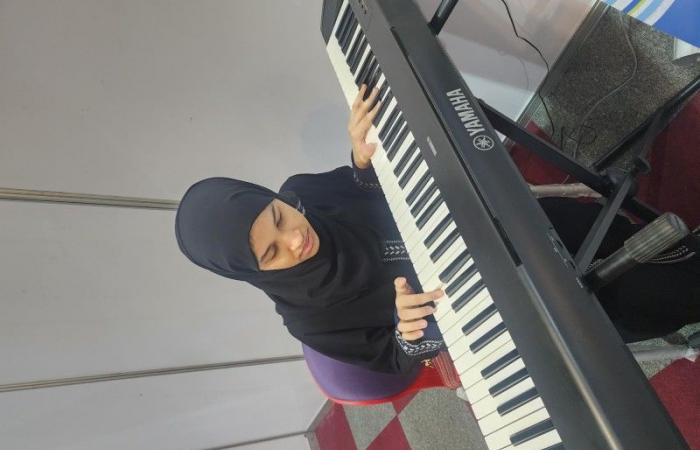 «كفيفة» تبهر زوار معرض الشرق الأوسط بالعزف على البيانو